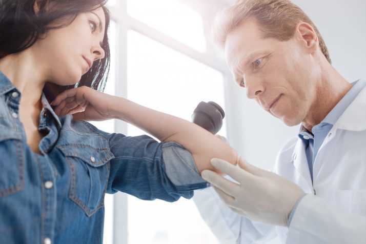 doctor examining patients arm